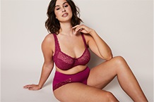 Woman in bra leaning against door frame
