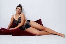 Woman in bra leaning against door frame
